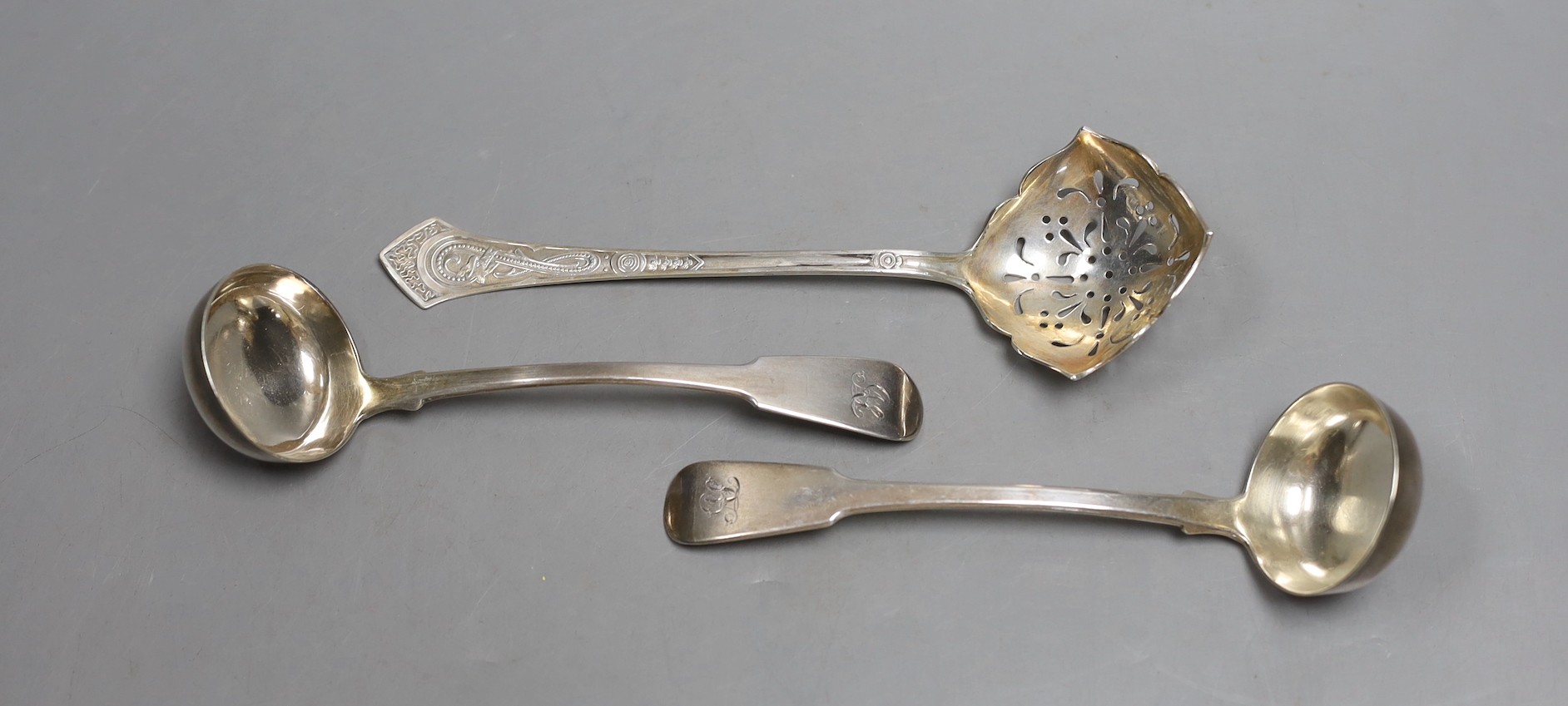 A pair of George IV Scottish silver fiddle pattern toddy ladles, James Mackay, Edinburgh 1827, and a Danish white metal sifting spoon.